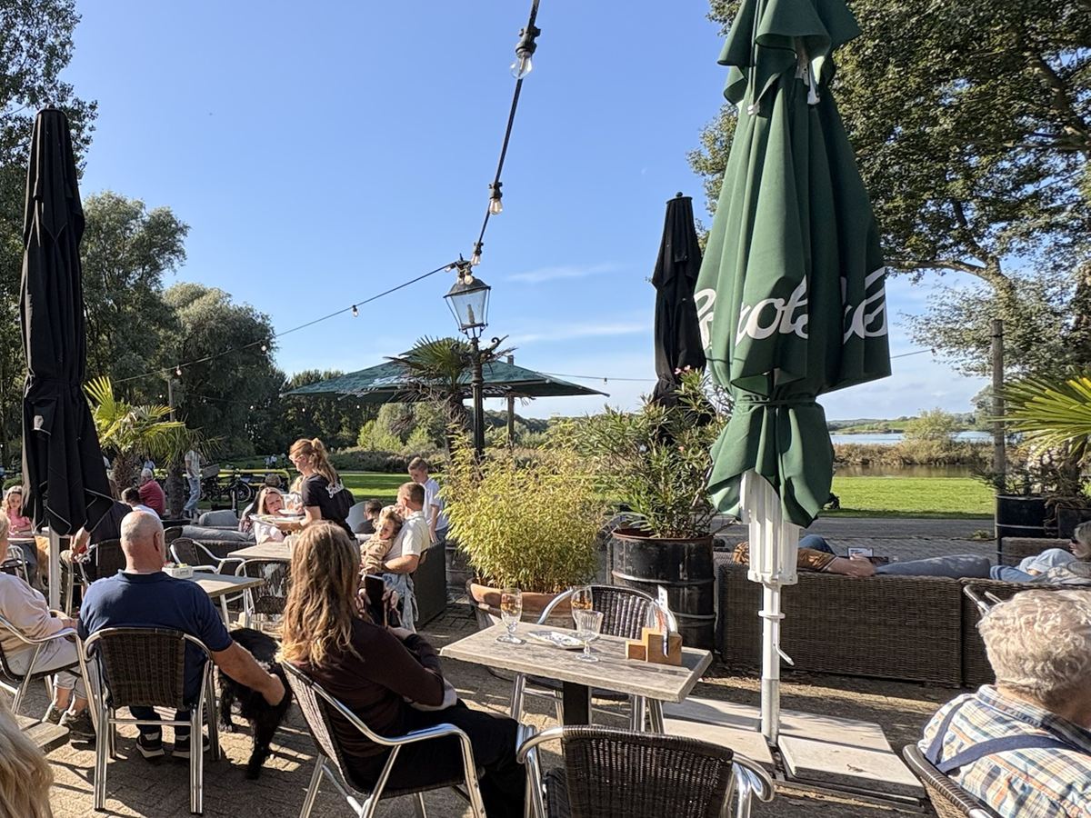 Een vol terras in de zon bij Lovers & Hunters, met uitzicht over het Zomerdel